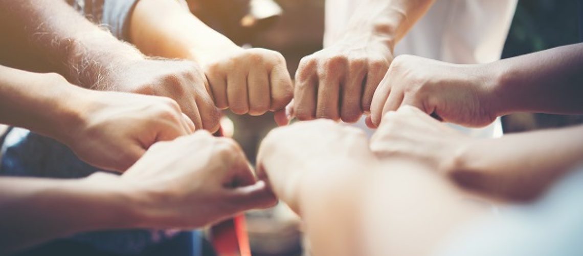 Close up of young people putting their hands together. Team with