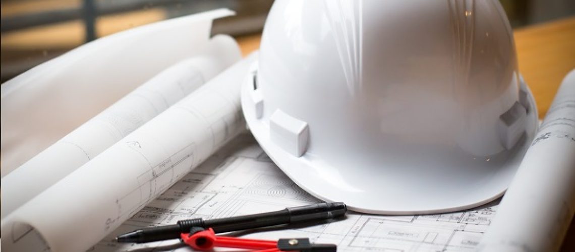construction concept image helmet rolled blueprints on wooden bo